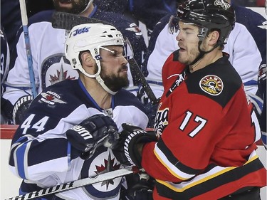 Winnipeg Jets' Zach Bogosian, left, tries to rough up Calgary Flames' Lance Bouma during game action at the Saddledome in Calgary, on February 2, 2015.