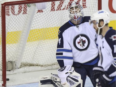Winnipeg Jets' goalie Michael Hutchinson looks dejected after the fourth goal scored against him during game action against the Calgary Flames at the Saddledome in Calgary, on February 2, 2015.