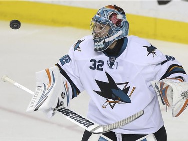 San Jose Sharks' goalie Alex Stalock bats at a loose puck during game action against the Calgary Flames at the Saddledome in Calgary, on February 4, 2015.