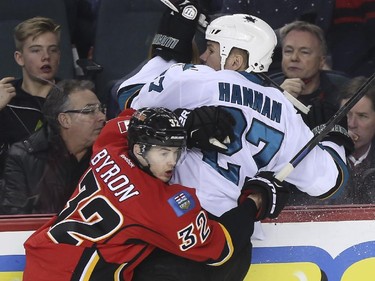 Calgary Flames' Paul Byron, checks San Jose Sharks' Scott Hannan during first period action at the Saddledome in Calgary, on February 4, 2015.