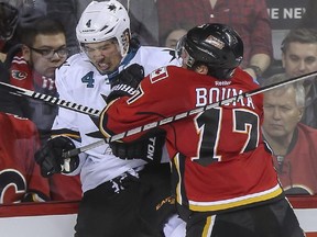 Calgary Flames forward Lance Bouma knocks San Jose's Brenden Dillon into the boards during their Feb. 4 meeting at the Saddledome. The teams renew hostilities on Monday in San Jose.