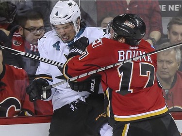 Calgary Flames Lance Bouma knocks San Jose Sharks' Brenden Dillon into the boards during third period action at the Saddledome in Calgary, on February 4, 2015. The Flames came out on top 3-1.