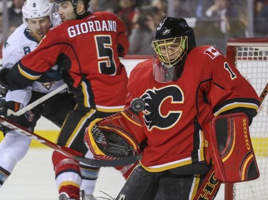 Calgary Flames' goalie Jonas Hiller makes a big save during game action against the San Jose Sharks at the Saddledome in Calgary, on February 4, 2015.