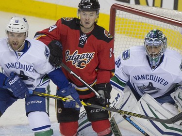 Calgary Flames Jiri Hudler, centre, waits for the shot in front of Vancouver Canucks net during game action at the Saddledome in Calgary, on February 14, 2015.