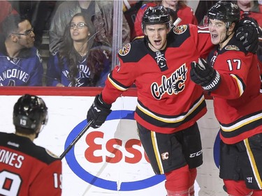 Calgary Flames Mikael Backlund, 11, Lance Bouma, 17,  and David Jones celebrate Bouma's game winning goal against the Vancouver Canucks during third period action at the Saddledome in Calgary, on February 14, 2015.