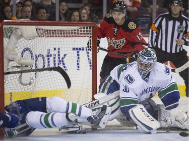 Calgary Flames Johnny Gaudreau watches as the pucks sits on the goal line just before Sean Monahan pokes it into the goal during game action against the Vancouver Canucks at the Saddledome in Calgary, on February 14, 2015.