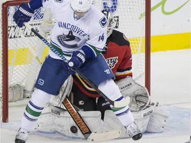 Calgary Flames goalie Karri Ramo makes the screen shot save during game action at the Saddledome in Calgary, on February 14, 2015.