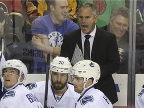 Vancouver Canucks head coach Willie Desjardins shouts instructions at his team, as they trailed the Calgary Flames by one during the last minutes of the third period at the Saddledome in Calgary, on February 14, 2015.
