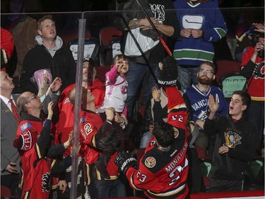 Sean Monahan is awarded first star of the game and gives his stick to a young fan in pink after adding Calgary Flames beat the Vancouver Canucks 3-2 at the Saddledome in Calgary, on February 14, 2015.