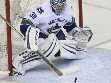 The Flames kept the pressure on Vancouver Canucks goalie, Ryan Miller, during game action at the Saddledome in Calgary, on February 14, 2015.