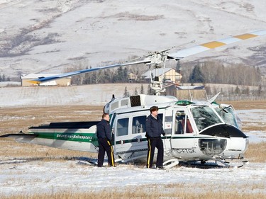 RCMP investigate a helicopter crash northeast of the Springbank airport on Wednesday Feb. 4, 2015. Two people aboard were injured in the crash one reportedly seriously