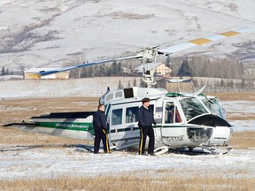 RCMP investigate a helicopter crash northeast of the Springbank airport on Wednesday Feb. 4, 2015. Two people aboard were injured in the crash - one reportedly seriously.