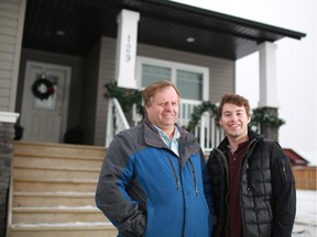 Gary Parker and his son Peter stand outside  in their home in the High River neighbourhood of Hampton Hills on Tuesday February 10, 2015. The Parker family bought the home after the 2013 flood.