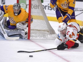 Calgary Flames left wing Jiri Hudler, right, of the Czech Republic, falls as he passes the puck under pressure from Los Angeles Kings defenceman Matt Greene during the first period of an NHL hockey game, Thursday, Feb. 12, 2015, in Los Angeles. The Kings won 5-2.