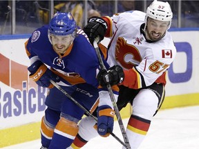 New York Islanders' Kael Mouillierat, left, and Calgary Flames' Emile Poirier chase the puck during the first period of the NHL hockey game, Friday, Feb. 27, 2015, in Uniondale, N.Y.