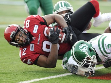 Calgary Stampeders' Nik Lewis, left, is tackled by Saskatchewan Roughriders' Macho Harris during the CFL 2012 Western semi-final.