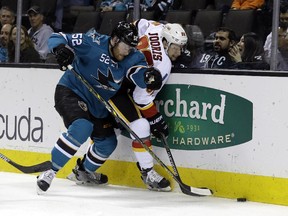 Calgary Flames forward Josh Jooris, right, is pressed against the boards by San Jose Sharks' Matt Irwin during Monday's game.