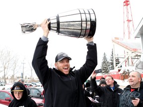 Stamps offensive lineman Dan Federkeil holds the Grey Cup after the champs returned to Calgary the day after last season's big game. On Wednesday, Federkeil signed a contract extension with Calgary.