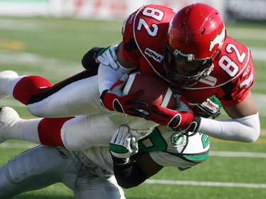 Calgary Stampeders slotback Nik Lewis flies into the endzone over an unidentifed Saskatchewan Roughriders defender to score his team's second touchdown of an August 2006 game.