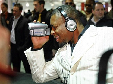 Calgary Stampeders receiver Nik Lewis tapes his teammates at the baggage carrousel as the team arrives at Montreal's Pierre Trudeau Airport for the 2008 Grey Cup game.