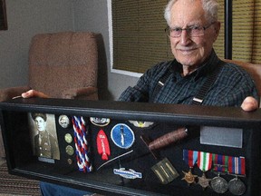 Ninety-seven-year-old Bernard Cooper holds the case containing his medals and mementoes from his days in World War II fighting in Europe with the Devil's Brigade at his Calgary home Monday February 2, 2015.