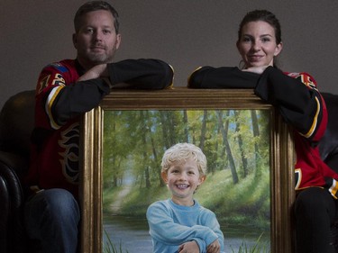 Rod, left, and Jennifer O'Brien, parents of missing child Nathan O'Brien, with the oil painting of Nathan gifted to them at Christmas by John Seibels Walker, on the eve of the Nathan O'Brien charity hockey game at the Saddledome in Calgary, on February 4, 2015.