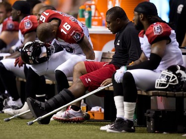 Calgary Stampeders' Nik Lewis, second right, uses crutches and wears an air cast on his left foot after injuring his ankle during the first half as he sits on the bench during the second half of a CFL football game against the B.C. Lions in Vancouver, B.C., on August 17, 2013. The injury cost him the rest of the season and some would argue he wasn't the same Nik Lewis in 2014.