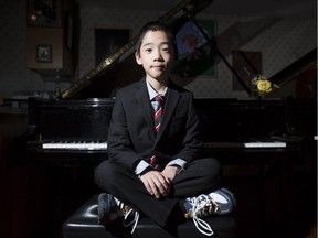 Kevin Chen, a nine year-old piano prodigy, poses for a photo at a piano with his suit and sneakers in Calgary, on February 3, 2015.