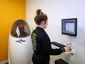 Personal trainer Vanessa Copiak monitors results from the Bod Pod, a pressurized body composition machine, for patient Ricardo Charles at INLIV.