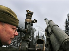 Sgt. Dave Jarrell, commander of Canadian Forces 1st Royal Canadian Horse Artillery B Battery, checks to make sure the team's 105-mm Howitzer is precisely on target during a demonstration of how they use the artillery piece to control avalanches in the Rogers Pass.