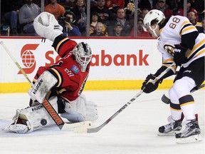 Calgary Flames goalie Karri Ramo stones Boston Bruins winger David Pastrnak during a game last week. Ramo will kick off the Flames' seven-game road trip on Tuesday night against the New York Rangers.