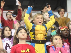 Seven-year-old Kieran Jordan stands up and cheers a goal by Nathan's Heroes at the Nathan O'Brien Children's Foundation hockey game Thursday February 5, 2015 at the Saddledome.