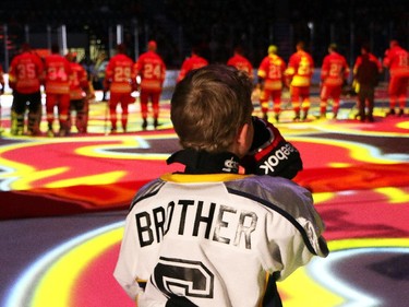 Luke O'Brien listens to the national anthem prior to the  start of the  Nathan O'Brien Children's Foundation hockey game Thursday February 5, 2015 at the Saddledome. A team made up of Nathan's family, local police and politicians took on a Calgary Flames Alumni squad.
