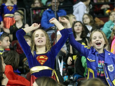 Seven year old Poet Rowley, left, and Scarlett Robichaud from Holy Names School stand up and cheer a goal by Nathan's Heros at the Nathan O'Brien Children's Foundation hockey game Thursday February 5, 2015 at the Saddledome. A team made up of Nathan's family, local police and politicians took on a Calgary Flames Alumni squad. Kids from the Holy Names school choir, grades one to six, took up the better part of a section in support of the O'Briens.