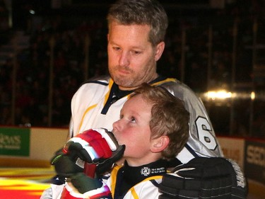 An emotional Rod O'Brien and his son Luke watch a video on the jumbotron of Luke's brother Nathan before the start of the  Nathan O'Brien Children's Foundation hockey game Thursday February 5, 2015 at the Saddledome. A team made up of Nathan's family, local police and politicians took on a Calgary Flames Alumni squad.