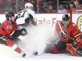 Pittsburgh Penguin captain Sidney Crosby looks back as his shot goes past Calgary Flames netminder Jonas Hiller and defender Paul Byron during the second period at the Saddledome Friday February 6, 2015.
