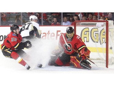 Pittsburgh Penguins captain Sidney Crosby looks back as his shot goes past Calgary Flames netminder Jonas Hiller and defender Paul Byron during the second period at the Saddledome Friday February 6, 2015.