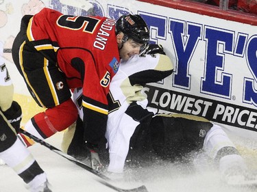 Mark Giordano of the Calgary Flames hauls down centre Evgeni Malkin of the Pittsburgh Penguins behind the Flames net during the first period at the Saddledome Friday February 6, 2015.