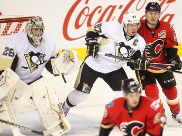 Jiri Hudler of theCalgary Flames mixes it up with Pittsburgh Penguins captain in front of the Penguins goalie Marc-Andre Fleury  during the first period at the Saddledome Friday February 6, 2015.