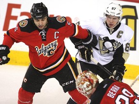 Pittsburgh Penguins captain Sidney Crosby battles against Calgary Flames counterpart Mark Giordano during a game between the teams last season.