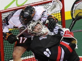 Calgary Roughnecks goalie Frankie Scigliano is tackled by Buffalo Bandits' Ryan Benesch during Saturday's National Lacrosse League game.