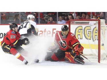 Penguin captain Sidney Crosby looks back as his shot goes past Calgary Flames netminder Jonas Hiller and defender Paul Byron during the second period at the Saddledome Friday February 6, 2015.
