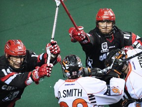 Calgary Roughneck Jeff Moleski, left and Greg Harnett tangle with Buffalo Bandits players during National Lacrosse League action at the Scotiabank Saddledome on Saturday Feb. 7, 2015.