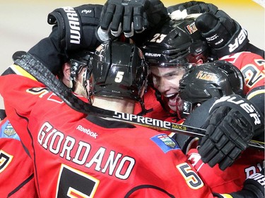 The Calgary Flames, including Sean Monahan, centre, and Mark Giordano, celebrate TJ Brodie's overtime goal which gave them a 4-3 win over the Boston Bruins at the Saddledome Monday February 16, 2015.