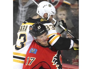 Boston Bruins captain Zdeno Chara gets his elbow in the face of Lance Bouma in the Bruins end during the second period at the Saddledome Monday February 16, 2015.