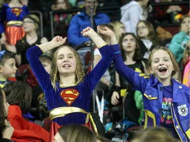 Seven-year-old Poet Rowley, left, and Scarlett Robichaud from Holy Names School stand up and cheer a goal by Nathan's Heroes at the Nathan O'Brien Children's Foundation hockey game on Thursday February 5, 2015 at the Saddledome.