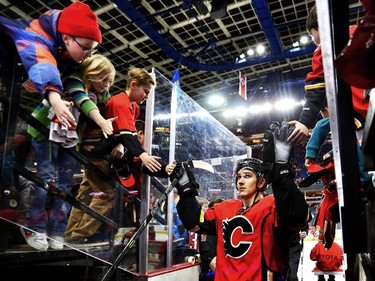 Calgary Flames Mikael Backlund  greets young fans as he leaves the ice after warmup before Wednesday's game against the Minnesota Wild at the Scotiabbank Saddledome in Calgary on February 18, 2015.