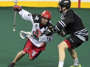 The Calgary Roughnecks' Shawn Evans, left, battles with the Edmonton Rush's John Lintz during their NLL west final playoff game at the Scotiabank Saddledome in Calgary, Alberta Saturday, May 10, 2014.