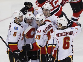 Mark Giordano, left, celebrates a goal against the New Jersey Devils on Wednesday night with teammates Sean Monahan, , Jiri Hudler, Johnny Gaudreau  and Dennis Wideman. The Flames' captain and best player was hurt in the dying seconds of Calgary's 3-1 win, but the team isn't revealing what the injury is or the prognosis for a return to the ice.