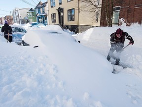 Justin Lynch digs out his car in Saint John, N.B., on Tuesday, February 3, 2015. A state of emergency was declared Tuesday in Saint John, N.B., after the third storm in less than a week pummelled the port city overnight and left its streets choked with snow.